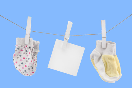 small mittens and socks for newborns on a rope with an empty sign, copyspace, mockupの写真素材