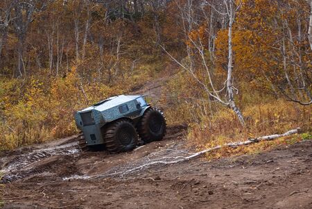 all-terrain vehicle with big wheels overcoming a dirty road