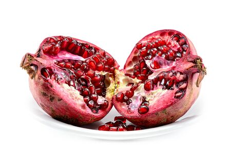peeled pomegranate seeds in a cup along with a fraction of fresh pomegranate isolated on white backgroundの写真素材