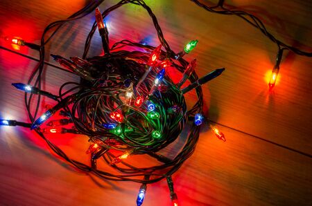 lights from a Christmas garland in a dark room, burning light bulbs, winter Christmas mood