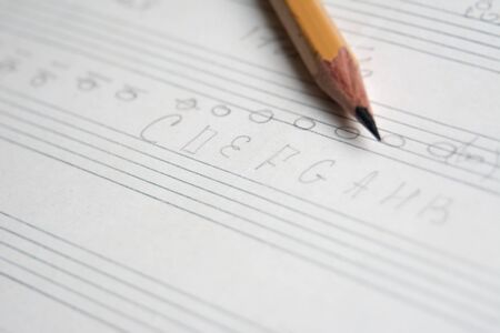 pencil on a musical notebook close-up, abstract musical notes and chords, musical backgroundの写真素材