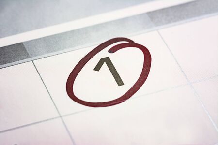 the first day of the month highlighted on the calendar with a red frame close-up macro, a mark on...