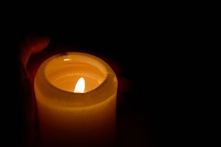 the flame of burning candles close-up macro on a dark black backgroundの写真素材