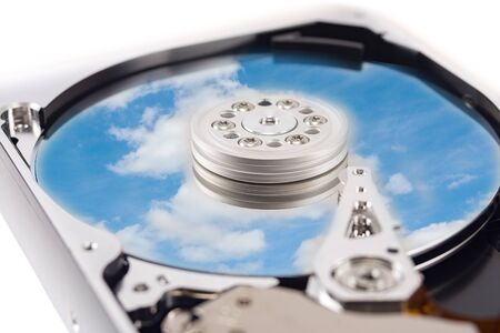 disassembled hard drive with the backdrop of clouds, the concept of cloud storage on white...