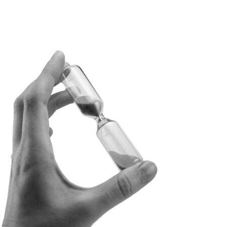 hand holding hourglass isolated on white background, black and white, sandglass