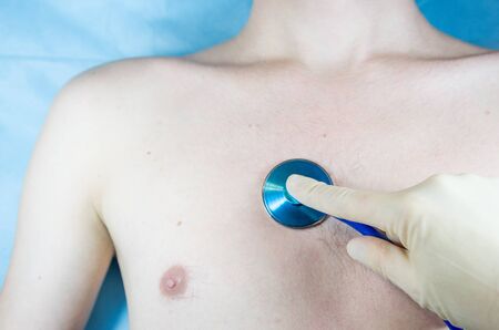 the doctor conducts auscultation of the patient, listening through a phonendoscope, pneumonia, cough, stethoscopeの写真素材