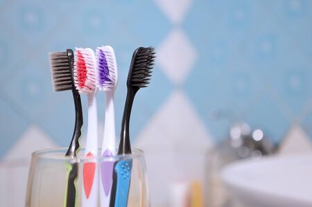 multi-colored toothbrushes and electric toothbrush in the bathroom