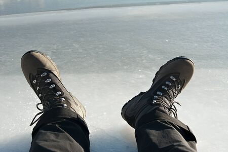 feet on frozen ice, frozen river, thick ice, man standing on ice