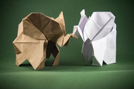 origami baby elephants made of craft paper on green background, paper and forest conservation concept, save paper save the forest, protect the animals, mockup, copy spaceの写真素材
