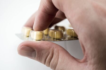 tablets poured from a container blister in hand close-up macroの写真素材