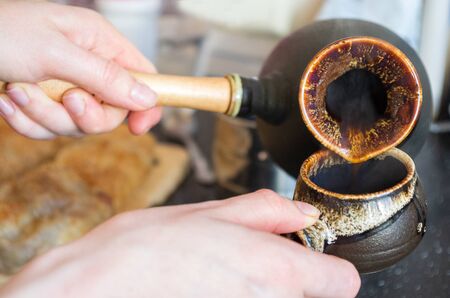 coffee with foam brewed in Turk close-up, traditions and culture