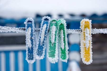 frozen clothes pegs on the street, cold and frosts, weather forecast cold, selective focusの写真素材