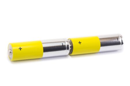 alkaline batteries and a yellow metal AA-size batteries isolated on white background closeup, carbon...