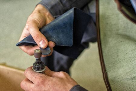 leather worker processes the product, polishes the edgesの写真素材