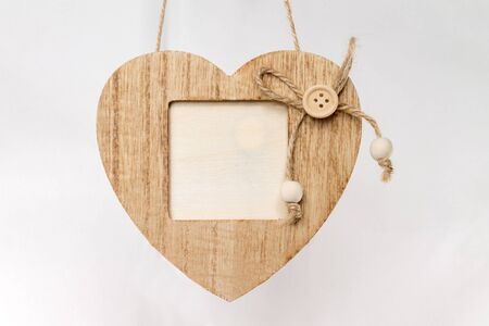 wooden photo frame in the form of a heart with free space, copy space, mock up, isolated on a light backgroundの写真素材