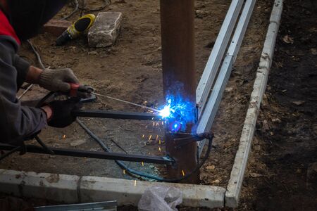 the work of the welding machine in the hands of the welder, welding sparks, industrial background