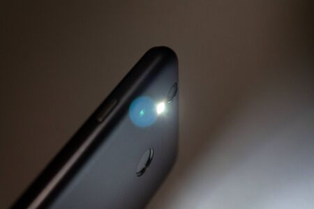 flashlight shining in the dark, flashlight in the smartphone on a dark background