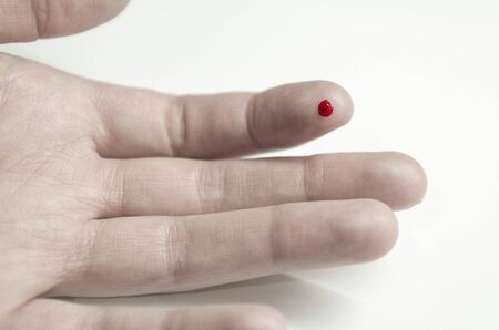 the wound on the hand on the finger close - up, cut, prick on the finger, a drop of blood on the fingerの写真素材