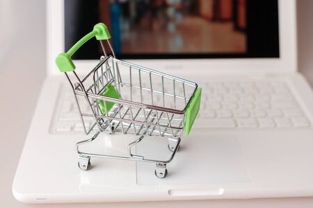 supermarket shopping cart on laptop background close-up, macro, online shopping concept and purchasing power, consumer shopping cartの写真素材