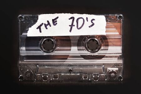 vintage old film music cassette on a black background with the inscription the 70â€™s,...