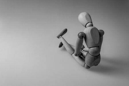 human figurine depicting a lonely bored person, the concept of abandonment and uselessness, despair and depression, autism, mental disordersの写真素材