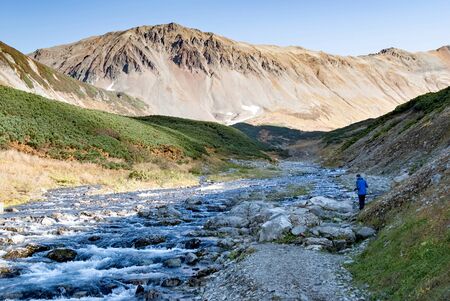travelers crossing a mountain fast river over a crossing over rocks, Hikingの写真素材