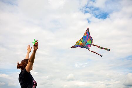 kite in hand against the blue sky in summer, flying kite launching, fun summer vacationの写真素材