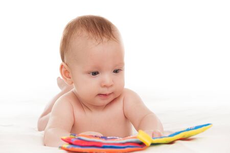 little happy motivated child is playing with dangling rattles, toys for newborn, first toy, isolated on white background, copy space, designの写真素材