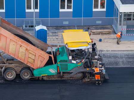 Industrial heavy road paver multifunctional modern, repair of road pavement in an urban environment, noisy work in the cityの写真素材