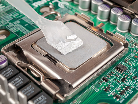 Applied thermal paste on the thermal distribution cover, heat removal from the chip processor, motherboard, close-upの写真素材