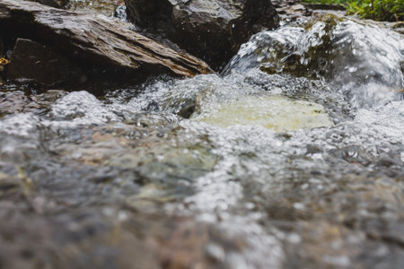 Raging water of a fast mountain river in a picturesque beautiful mountainous area, flowing water...