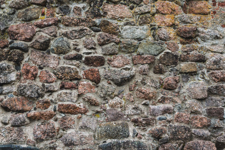 A stone background made of cobblestones, an ancient wall, a road lined with stonesの写真素材