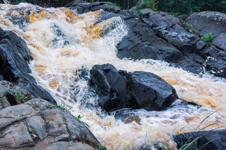 a bubbling fast cold river with cliffs and waterfalls, a mountain river with rapids and rocks