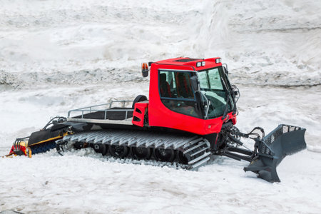 Large snowplow on tracks with a bucket, machine for paving mountain roads, for working on slopes...