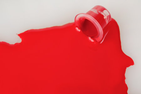 A jar with spilled red paint, paint background, pigments, ink for tattooing, close-upの写真素材