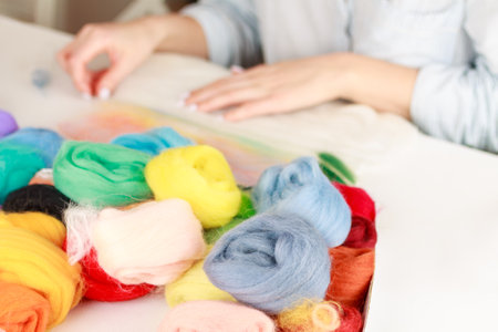 A girl is engaged in making handmade items from wool, making woolen paintings, handicraft weaving, selective focus close-upの写真素材