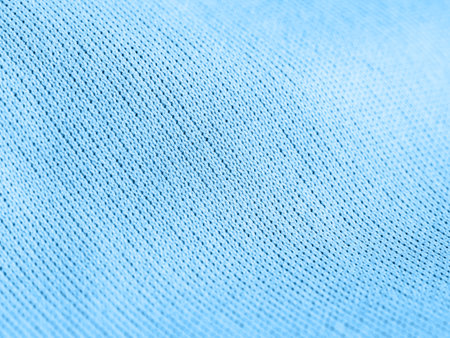 Factory textile fabric material surface blue colored background with thread close-up