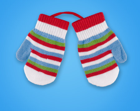 Warm light fabric wool gloves comfortable for cold weather isolated on blue background close-up, for the childrenの写真素材