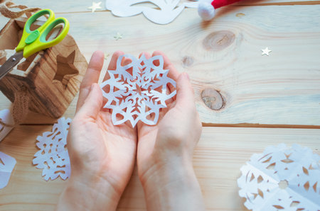 cutting out snowflakes from paper, New Year decorations toys, Christmas preparations at home,...