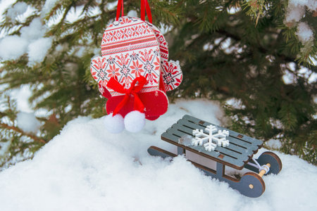 winter holiday background with toy mittens in hands against the backdrop of snowy weather and...