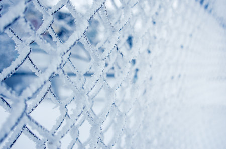 snow-covered fence in winter, fallen snow, frost and precipitation, freezing rain, close-upの写真素材