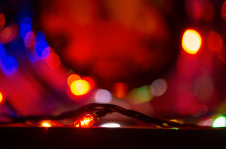 Blurred out-of-focus bright lights of a garland on a dark background close-up selective focus