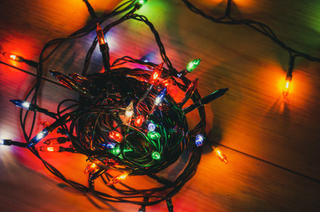 Blurred out-of-focus bright lights of a garland on a dark background close-up selective focusの写真素材