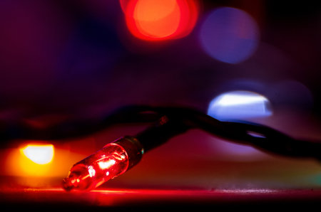 Blurred out-of-focus bright lights of a garland on a dark background close-up selective focus