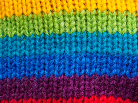 Close-up of bright multi-colored knitted wool fabric. Detailed textures and rich colors highlight the quality and appeal of this piece.の写真素材