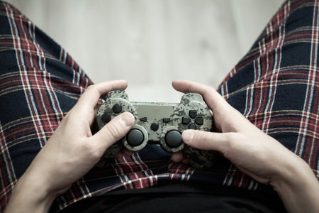 Joystick in hand: a person spends time playing games, a focused look, a relaxed position.
