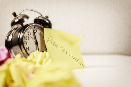 Procrastination: Close-up of an alarm clock and sticky notes, symbolizing procrastination and looming deadlines.の写真素材