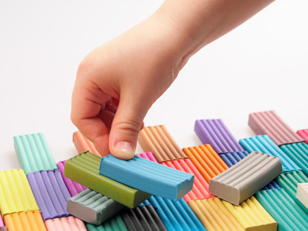 The child holds bright plastic clay in his hands, demonstrating the soft texture and rich colors of the material.の写真素材