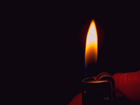 The lighter produces a spark, creating fire. Symbol of danger, potential explosion and fire. Ideal for warnings.の写真素材