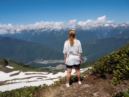 A lonely person standing against the backdrop of majestic mountains creates an atmosphere of adventure and the search for harmony with nature.の写真素材